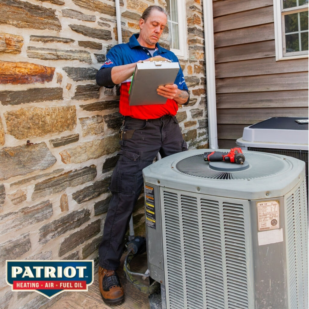 an HVAC technician from Patriot Heating, Air and Fuel Oil performing summer AC maintenance at a Bucks County, PA home