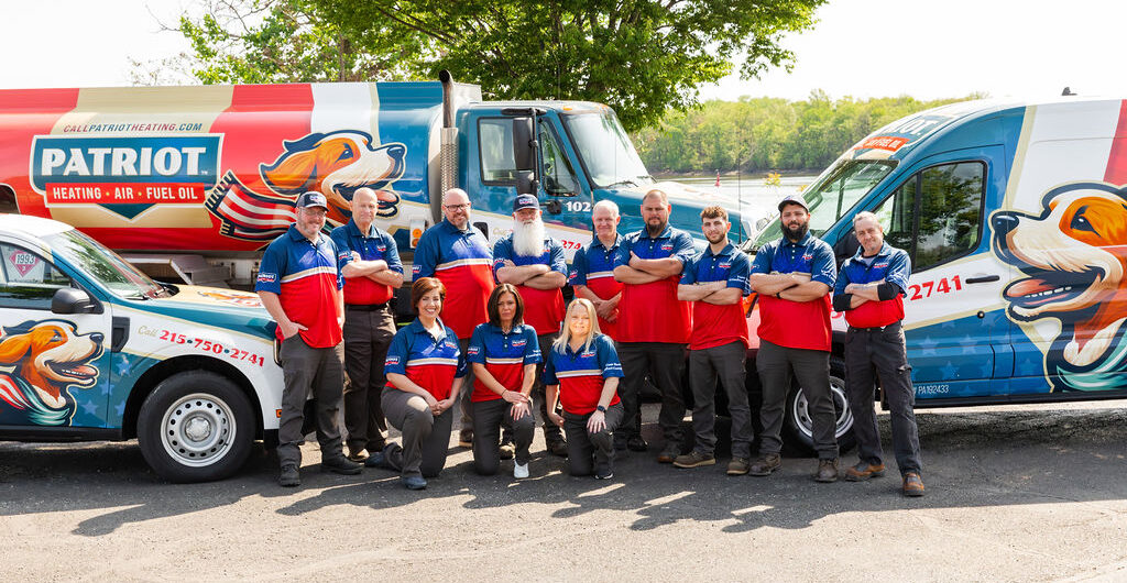 Croydon heating services crew standing in front of Patriot-branded vehicles