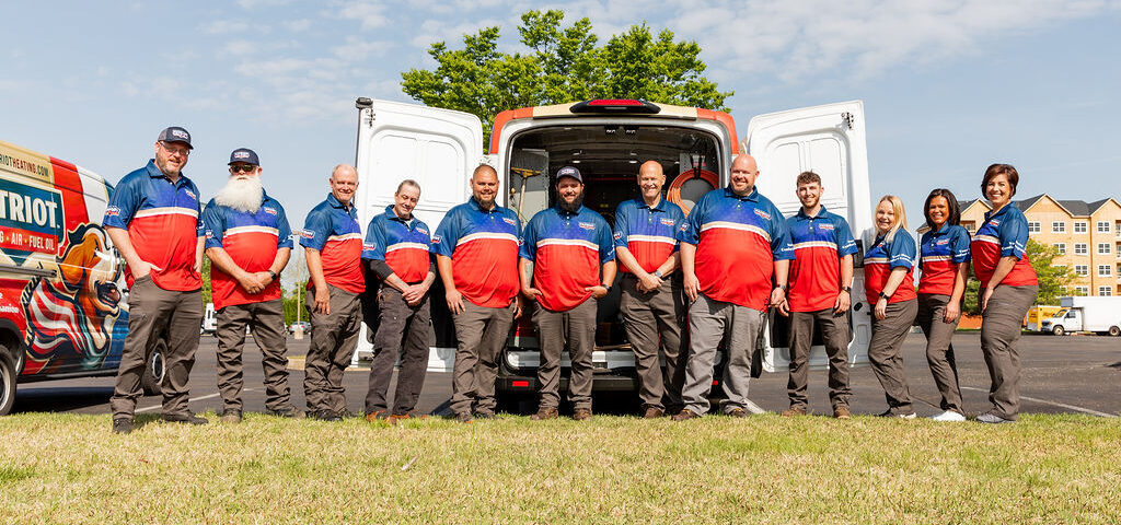 Group of Patriot Heating employees in front of branded trucks ready to offer Langhorne heating services