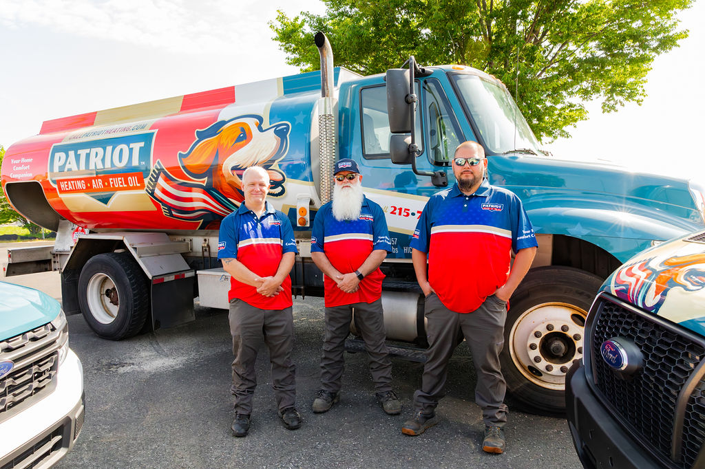 three technicians from Patriot Heating, Air and Fuel Oil stand in front of a branded truck ready to deliver fuel oil in Bensalem, PA