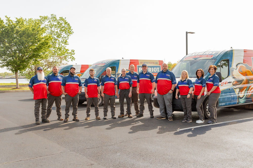 a group photo of Patriot Heating, Air and Fuel Oil’s AC services crew standing in front of branded vehicles in Bensalem, PA
